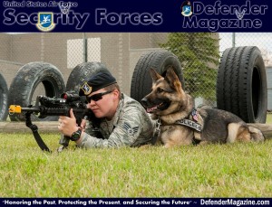 Senior Airman Heather Johnson, 5th Security Forces Squadron military working dog handler, fires blanks during weapons training as her MWD Cyndy lies next to her on Minot Air Force Base, N.D., July 29, 2014. This training allows handlers to familiarize their dogs with the sound of gun fire and gauge what their reaction will be in a combat situation. (U.S. Air Force photo/Senior Airman Stephanie Morris)